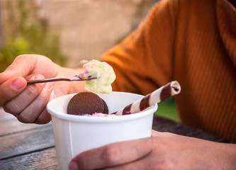 Close Up of white cup with sweet dessert Thai ice cream made from strawberry and lemon and woman are using a small spoon to scoop the ice cream. Healthy eating concept, Select Focus. Top view.