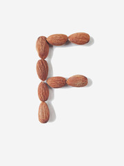 Isolated alphabet letter F made by almonds