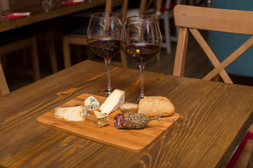 Red wine and assorted cheese plate with sausage