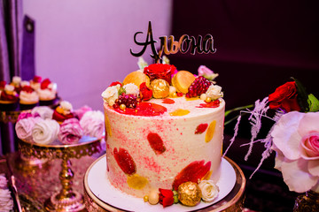Fine cake decorated of candies and roses with the inscription 