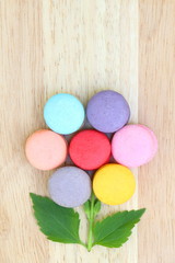 Closeup top view of colorful macarons stack like flower on wood background have copy space. Flat lay style.