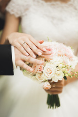 Perfect wedding couple holding luxury bouquet of flowers