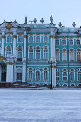 Fototapeta na wymiar Winter Palace facade architecture on cold winter day with snow in St. Petersburg, Russia. Building exterior with empty street in front on Palace square, main city landmark 