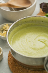 Fresh made broccoli cream soup in cooking pan. selective focus