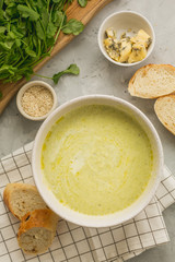 Broccoli cream soup with bread, cheese and greens