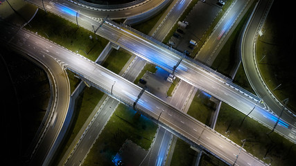 Aerial high drone flight over evening road traffic in Sochi, Russia. Highway and overpass with cars and trucks, interchange, two-level road junction in the big city. Top view.