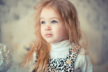 Little adorable blondie caucasian baby girl indoors smiling. Portrait on wooden background