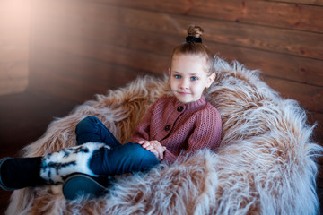 Portrait of teenage cute pretty adorable girl in knitted winter clothes on wooden background. Winter portrait, beauty kid concept