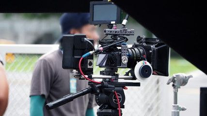 Video camera in film or movie production on tripod and professional gear which shooting in location...
