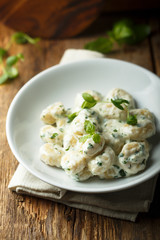 Homemade potato gnocchi with creamy basil sauce