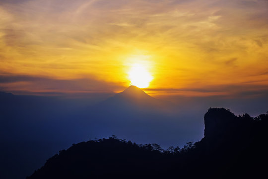 Beautiful sun is rising behind Mount Merapi, Yogyakarta. This is photographed in Puncak Suroloyo, Kulon Progo.