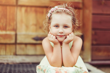 Outdoor portrait of cute blondie caucasian girl in countryside background