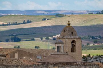 Church tower and roof with religious cross of Chiesa di Sant'Agostino, view of ancient town of Matera, Basilicata, Southern Italy, cloudy summer warm August day