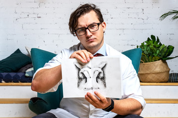 Serious professional  psychologist showing paper with Rorschach inkblot