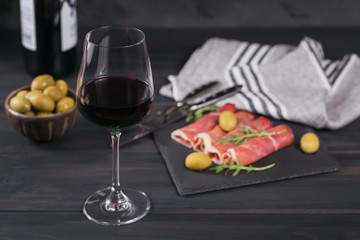 Black stone platter with slices of cured ham or Spanish jamon serrano or Italian prosciutto crudo