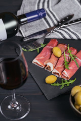 Black stone platter with slices of cured ham or Spanish jamon serrano or Italian prosciutto crudo