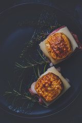 Sandwiches from puff pastry dough with ham and cheese with herbs