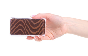 Chocolate cake biscuit in hand on a white background. Isolation