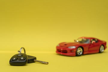 Car keys on yellow background. Red car purchase