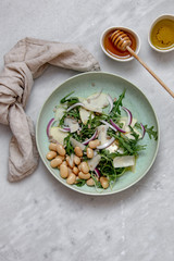 Vegan salad with beans arugula onions apple and vegan parmesan cheese