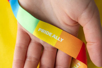 LGBT symbol - hand with rainbow ribbon and pride ally, the concept of support of the LGBT community