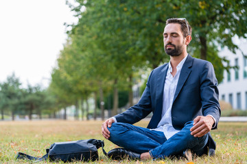 Relaxed businessman doing meditation in the park