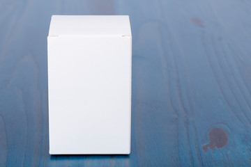 A white cardboard box on wooden background
