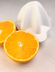 NARANJA CORTADA EN PRIMER PLANO Y EXPRIMIDOR