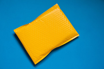 Yellow envelope made of bubble wrap for prevent something from bumping or shockproof on blue...