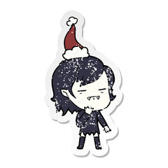 distressed sticker cartoon of a undead vampire girl wearing santa hat