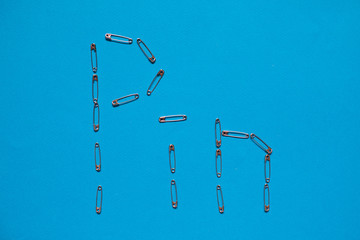 Word Pin made of safety pins on blue background