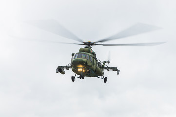 Military helicopter flying against the cloudy sky