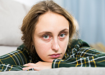Portrait of sorrowful woman sitting at home