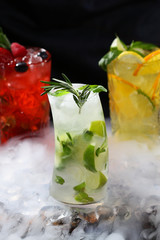 Three different lemonade in high crystal glasses on a black background. Restaurant or cafe concept