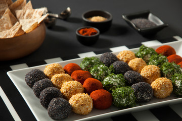 Cheese platter, appetizer. Spicy, sesame, blue poppy, red pepper, parsley cheese balls. With whole wheat chips