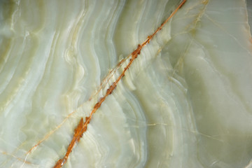Natural green onyx stone with a red stripe on the surface