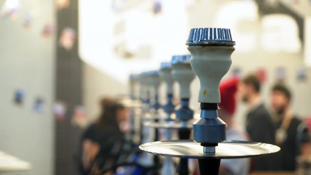 People choosing hookah. Smoking tobacco at exhibition. Shisha bowl at event