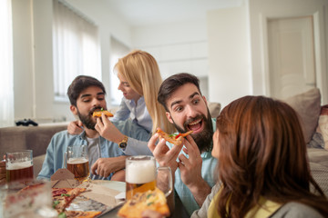 Group of happy young people eating pizza