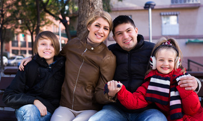 Family sitting on bench outdoors