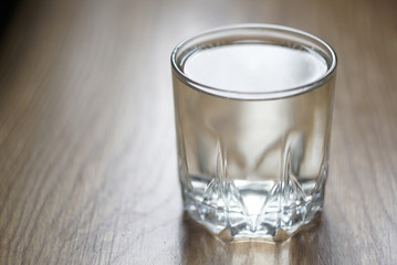 a glass of water on a wooden table   