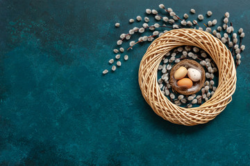 Obraz na płótnie Canvas Easter decoration – easter eggs in the nest and pussy willow. Top view, close up, flat lay