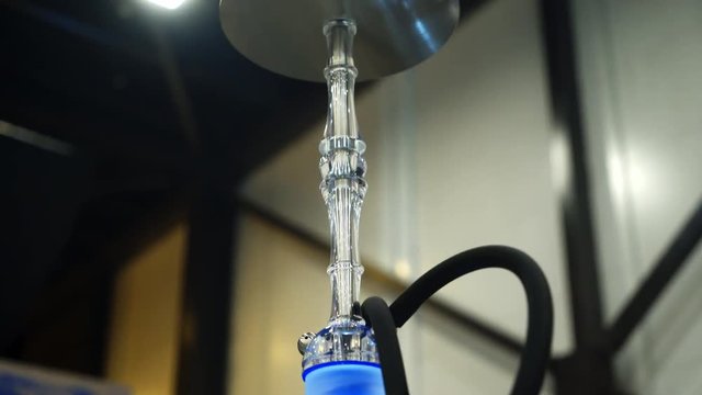People choosing hookah. Smoking tobacco at exhibition. Shisha bowl at event