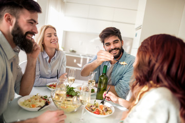 Group of friends enjoying meal at home together