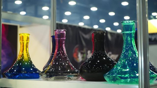 People choosing hookah. Smoking tobacco at exhibition. Shisha bowl at event