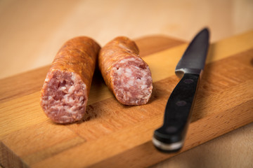 Frische Mettwurst Bierbeißer Wurst aus Schweinefleisch mit Messer auf Holz Brett 