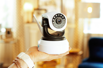 Closeup on wifi security camera in hand of modern woman