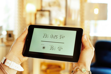 Closeup on smart home weather station in hands of housewife