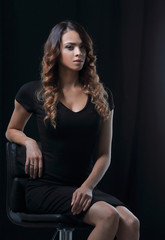 Obraz na płótnie Canvas young gorgeous caucasian brunette in dress on chair