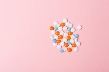 Different pharmaceutical medicine pills, tablets and capsules on light pink background. Copy space. Medicine medical concept. Be healthy.