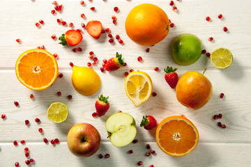 Fresh mixed fruits.Healthy eating, dieting.Love fruits, clean eating. Season fruits. Pomegranate seeds, apple, orange, lemon, strawberry on wood patterned background. 